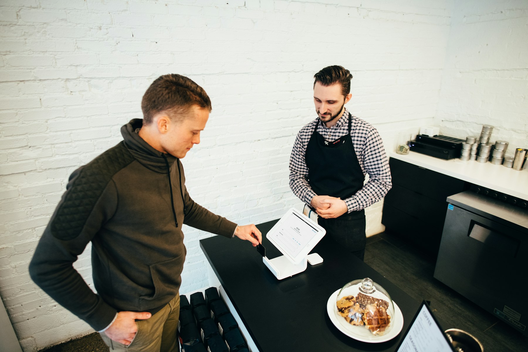 Small-business owner helping a customer at a local counter